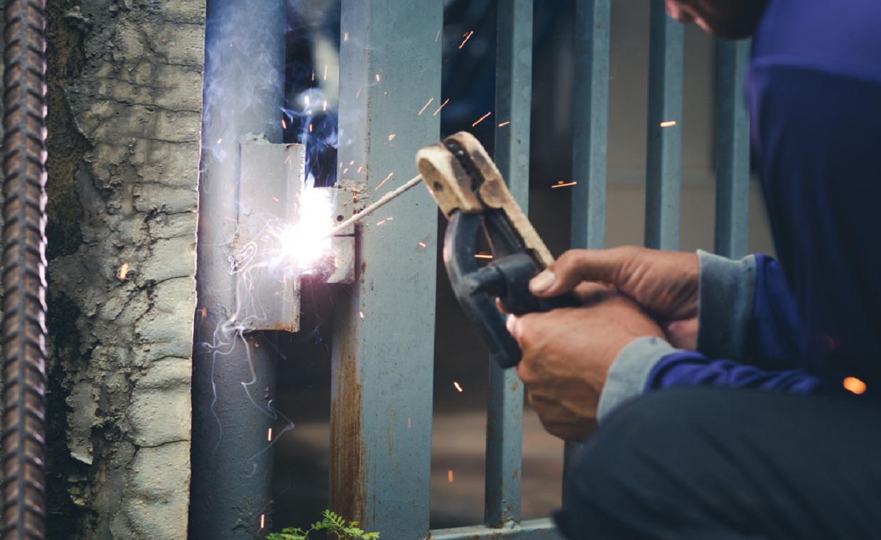 Engineer inspecting gate safety devices during a repair in London